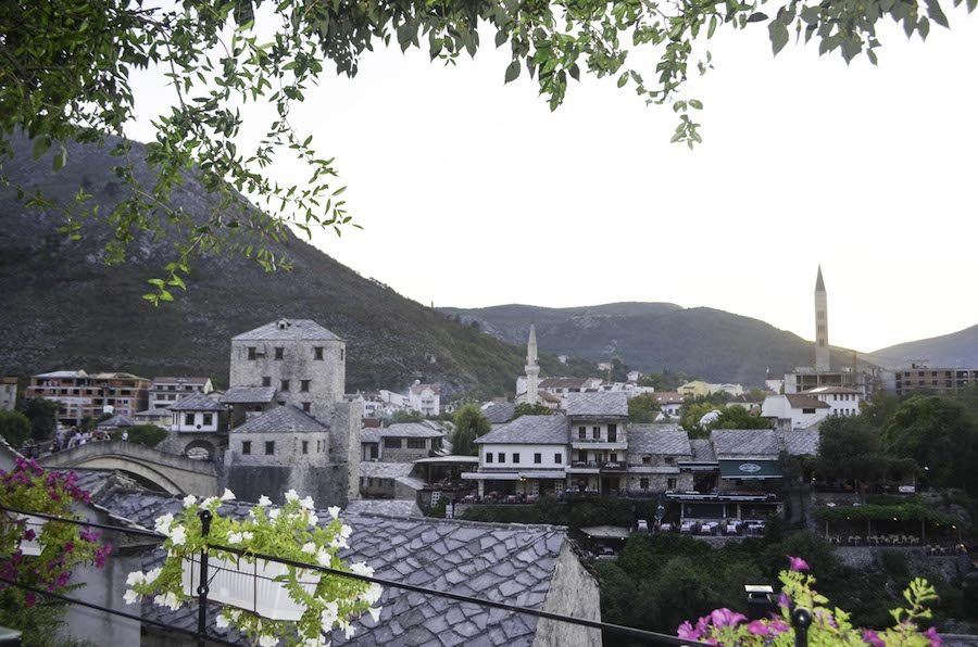 A view of a city with mountains in the background, taken during a day trip to Mostar.